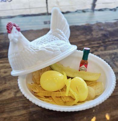 2 In-House picked eggs served over chips with a pickle and Tabasco. Comes served in super cute porcelain chicken.