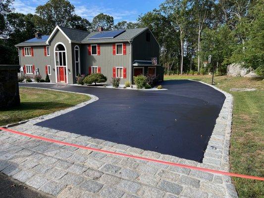 A driveway looks brand new after a layer of sealcoating.