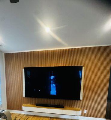 98 inch TV installation with panel wall and floating shelf and fiber density board