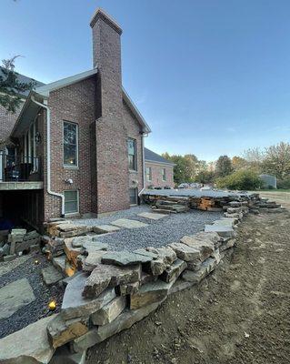 3 tiered stacked natural stone retaining wall with patio