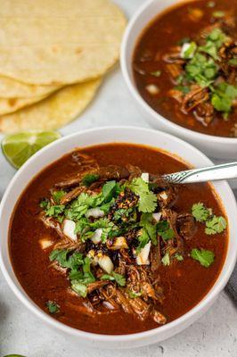 Nuestros caldos son sobre salientes en su perfección, como este caldo de Birria con tortillas hechas a mano.