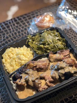 Oxtails on a bed of rice , mac n cheese with greens $24.99