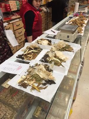 Staff at Hop Hing Ginseng Co. preparing a customer's order from Dr. Dai Shi Zhang