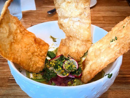 YELLOW FIN TUNA CRUDO / habanero sesame oil. radish. shallot. jalapeño. herb salad. avocado mousse . pistachio dust. crispy wontons