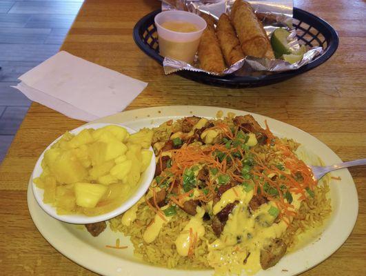 Huli huli chicken on yellow rice with a side of fresh pineapple and crab rolls with the BOMB.com sauce!!!!