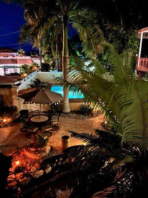 Courtyard with water feature, koi pond, heated pool, banana palms, seating.