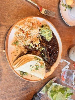 Carne asada with brown rice, black beans, guacamole and flour tortillas.
