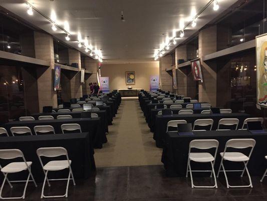 seminar tables with black linens and white chairs for a presentation