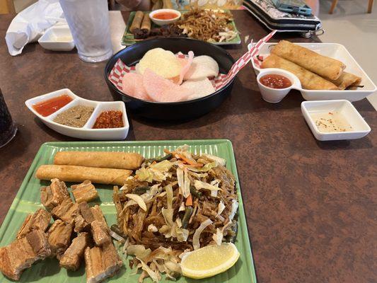 Pork belly with pancit and lumpia, shrimp chips, dynamite lumpia, chicken skewers with lumpia and pancit.