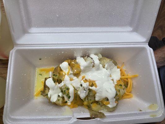 Half potato with butter, cheese, and sour cream