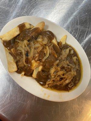 Hamburger Steak with fries smothered with caramelized onions and brown gravy