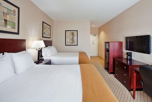 Standard Two Queen room features well-lit work desk with ergonomic chair, HDTV, fridge, microwave, and high-speed Internet.