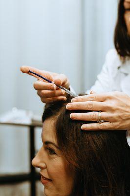 A hair growth serum is applied to the scalp during an Alma TED treatment. It has amino acids, peptides, and growth factors.