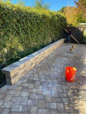 This here is a patio with pavers and a sitting bench.