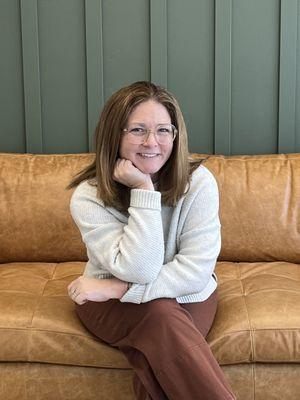 Jennie Denney, AMFT, in the community room at Radical Wellness in San Clemente--a space for growth, trust, and reflection.