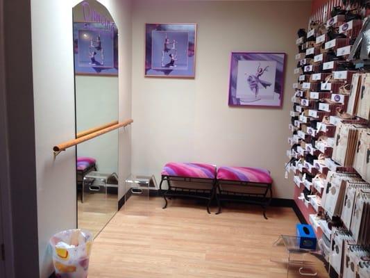 An area for trying on shoes. A mirror and place to sit.
