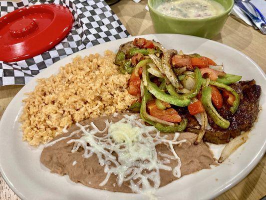 Steak with fajita veggies, rice, beans, and queso