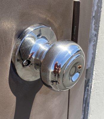 Door knob with screws facing outdoors.