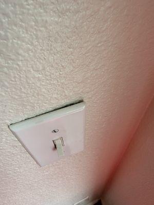 Light switch is detached from wall.
