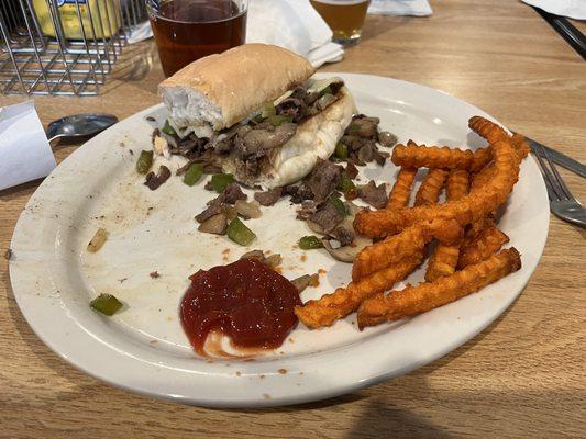 Half of the Philly sandwich snd sweet potato fries