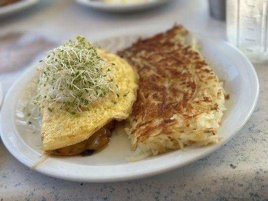 Gourmet Delight Omelette with mushrooms, spinach, topped with sour cream and hash browns