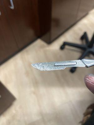 Dead skin cells on blade from a dermaplane facial