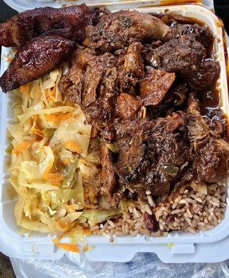 Stewed Chicken, with rice & peas, cabbage, plantains. The chicken is spiced differently with a hint of cinnamon. Tasty.