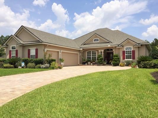 Burgundy shutters highlight the windows on this modern home, while a dark entry door provides a warm welcome. We take extra precautions when