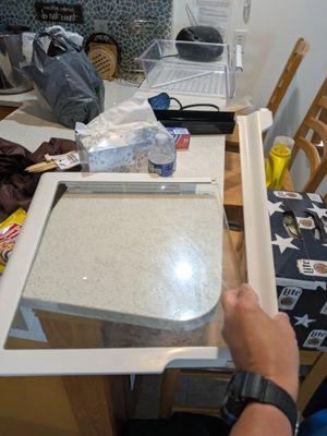 Broken fridge shelf and door. This was on the counter top when we arrived.