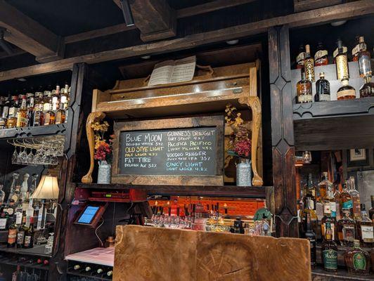 Player piano above the bar plays modern songs in a saloon style.