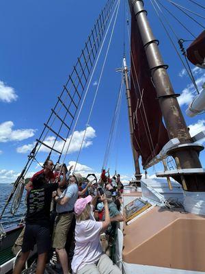 Sailing...volunteers helping raise the sails with staff