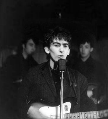 George performing in Hamburg, Germany (with John and Paul in the background)