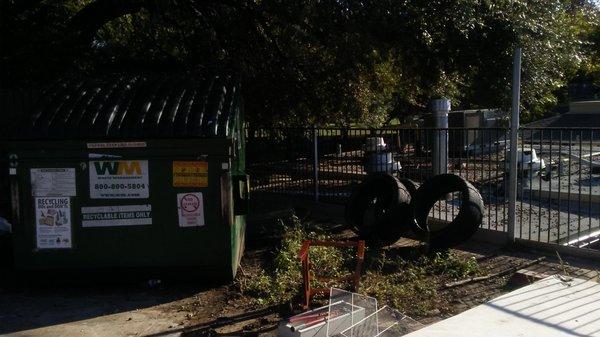 Mattress behind dumpster