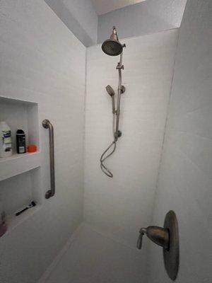 The new install with dual shower heads, safety bars, insets for soaps ets and water handle at the entry.