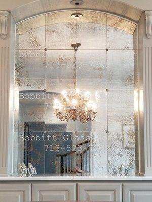 Antiqued mirrors installed in sections with rosettes.