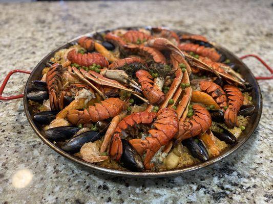 Seafood paella lobster clams mussels shrimp scallops crab legs