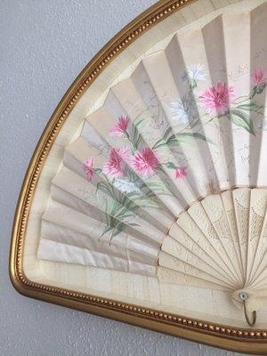 Close up: museum glass gives the illusion that the fan is floating and you can't see any stitching