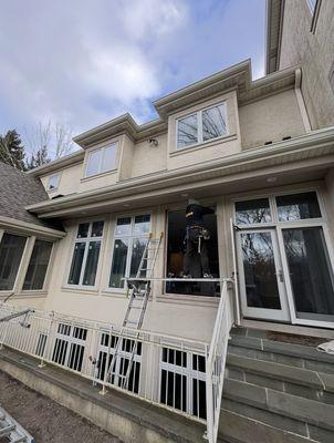 Window and door installation at a private house. A worker is installing them using a ladder.