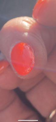 This nail was left rough on the edge and she didn't even paint the nail with precision.