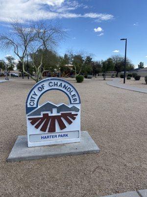 A few guys playing basketball & children on the playground.