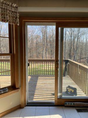 Looking out of a slider screen door installed with brand new Ultravue mesh in Thomaston, CT