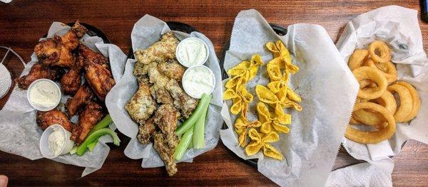 Left to right: Asian burst wings, parmesan garlic wings, spinach and artichoke rangoon, and onion rings.