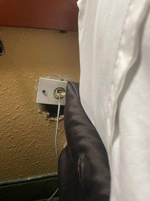 Phone jack behind bed with stain on bed skirt