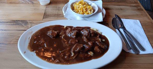 Rib tips and gravy over noodles, with a side of corn