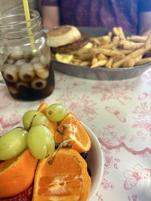 Breakfast sandwich, cold brew and fresh fruit.