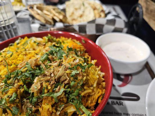 Shrimp Biryani, with a naan bread basket in the background.