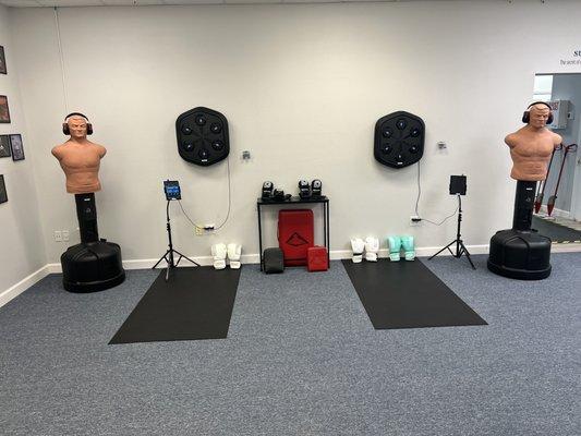 Our Fighting Wall features boxing machines that build rhythm, coordination, and striking skills -- a unique part of Urban Defense training