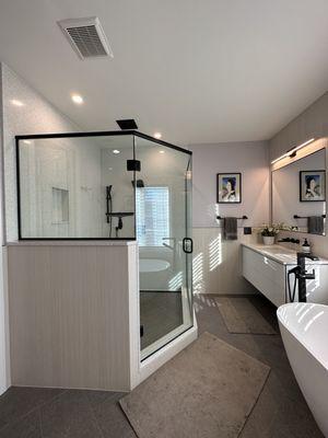 Custom shower with quartz walls, tile floor and recessed rain shower.