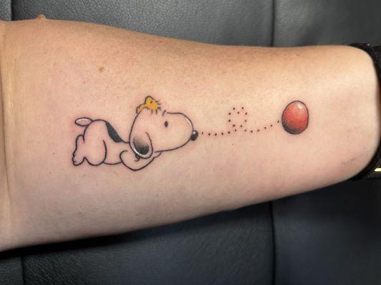 Snoopy with Woodstock looking at the ball