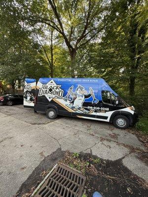 Drain cleaning van parked in rental property parking lot